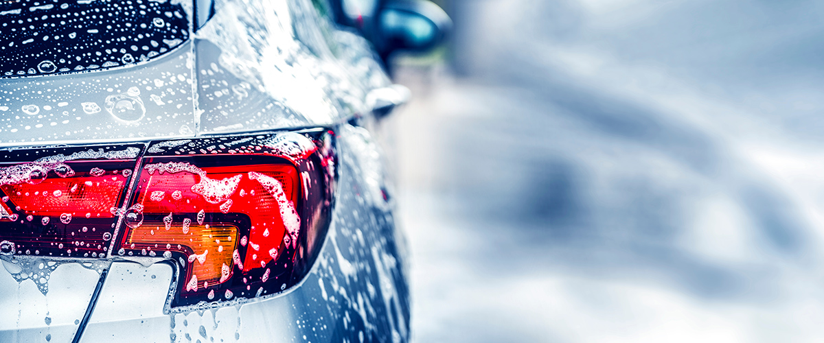 Image of the rear of a sedan, car at a car wash.