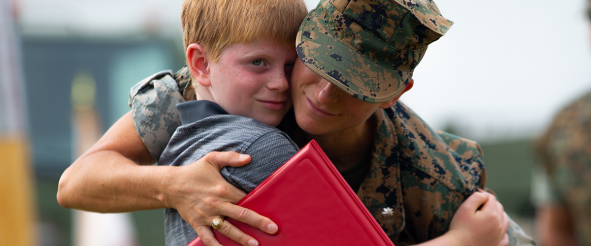 Marine hugging his young child.